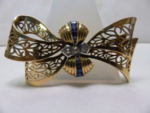 Broche para dama en forma de Lazo, en Oro de 18k y Diamantes talla Brillante Antigua.