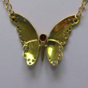 Cadena con colgante integrado, en Oro de 18k. en forma de Mariposa, con Rubí central de 0,60 ct. y 38 Diamantes talla Brillante de 1,10 ct. (I-J/SI1). 13,60 gr.