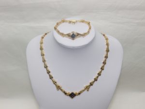 Conjunto de Collar y Brazalete en Oro, con eslabones en V, y rombo central cuajado de "blue strass" y circonitas.