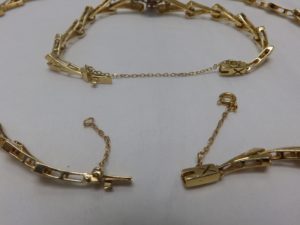 Conjunto de Collar y Brazalete en Oro, con eslabones en V, y rombo central cuajado de "blue strass" y circonitas.