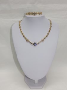 Conjunto de Collar y Brazalete en Oro, con eslabones en V, y rombo central cuajado de "blue strass" y circonitas.