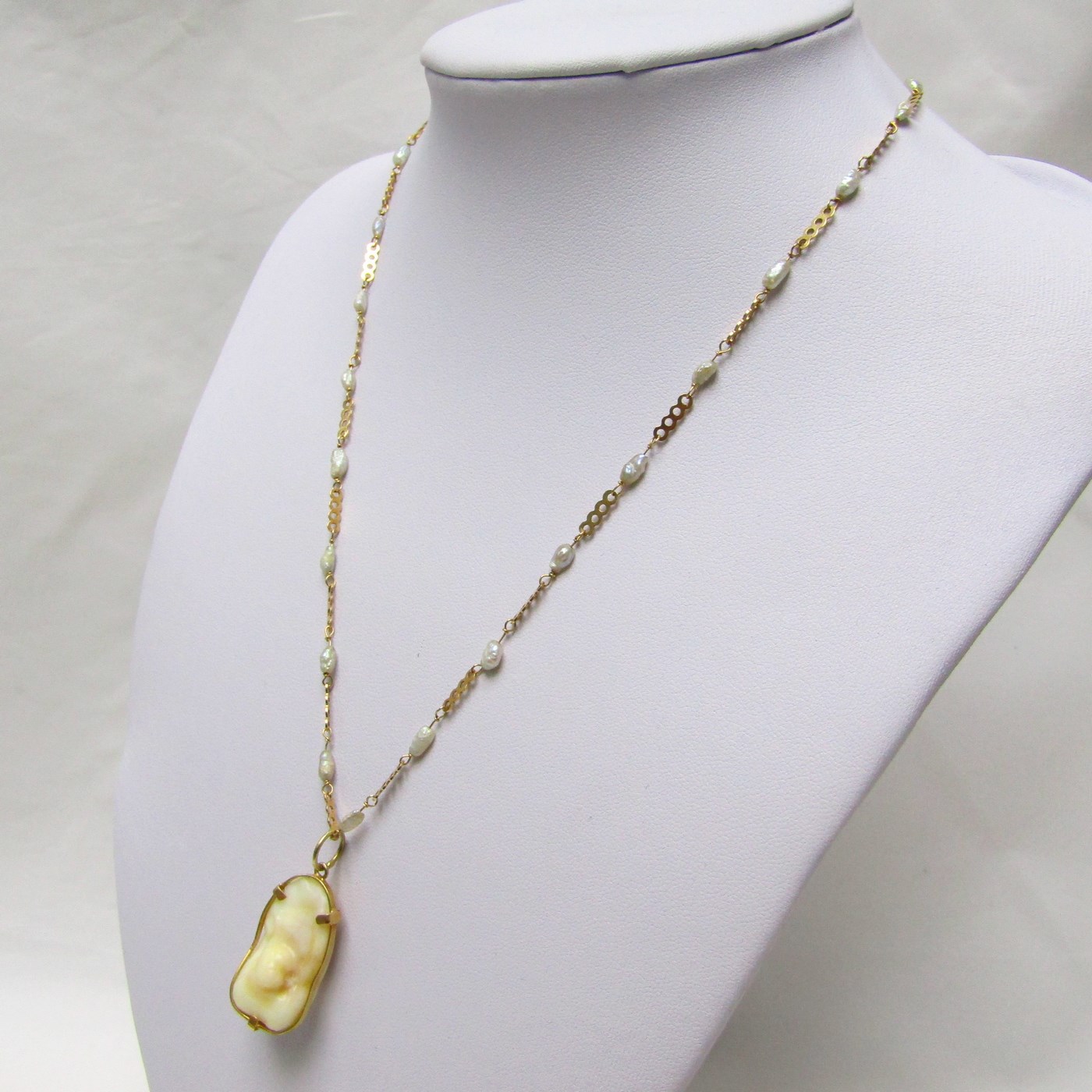 Gargantilla en Oro y Perlas Barrocas con amuleto (Otolito o Hueso de Corvina). Gargantilla en Oro y Perlas Barrocas con amuleto (Otolito o Hueso de Corvina).