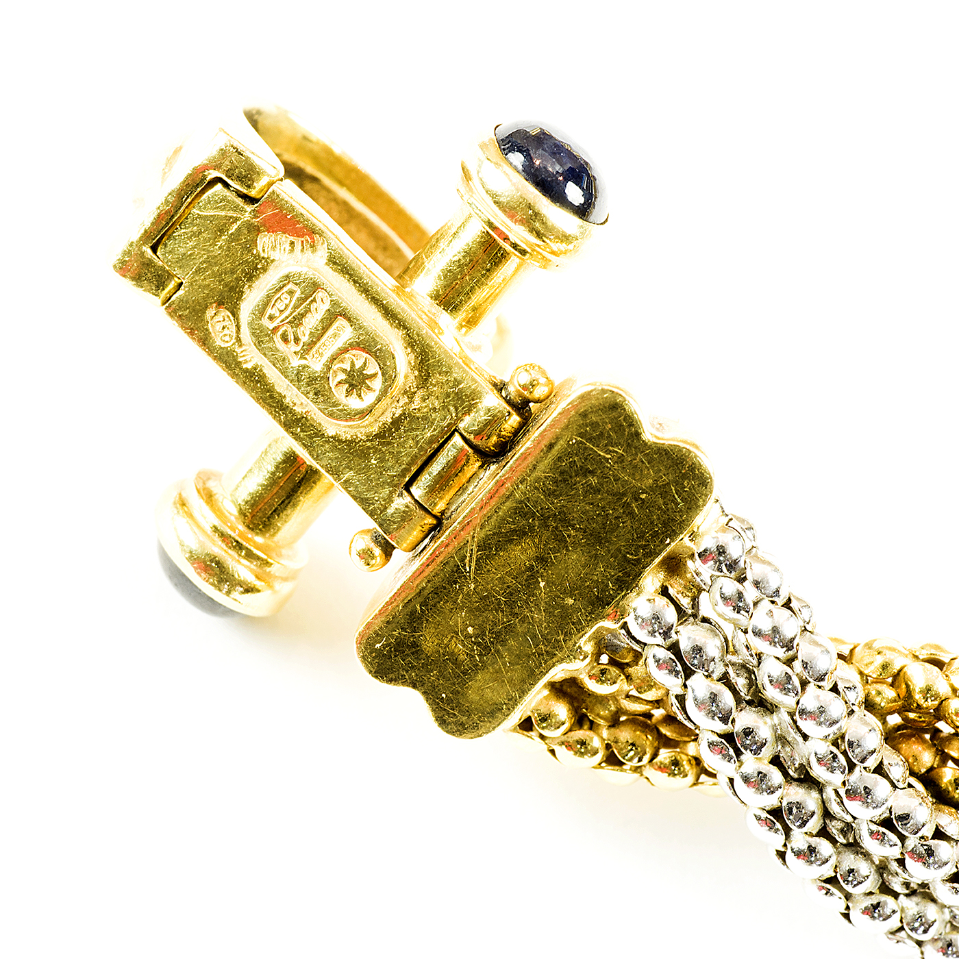 Pulsera en Oro Bicolor trenzada, con cabujón de zafiros. Pulsera en Oro Bicolor trenzada, con cabujón de zafiros.