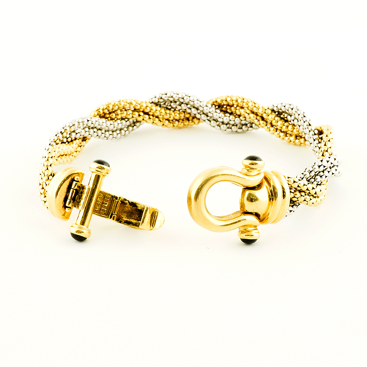Pulsera en Oro Bicolor trenzada, con cabujón de zafiros. Pulsera en Oro Bicolor trenzada, con cabujón de zafiros.