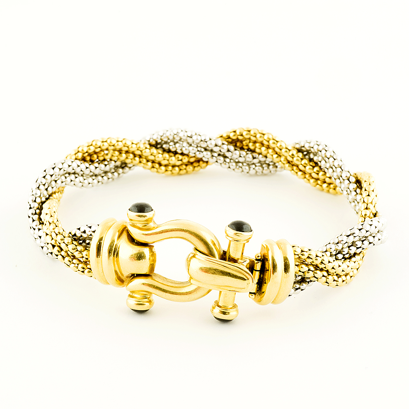 Pulsera en Oro Bicolor trenzada, con cabujón de zafiros. Pulsera en Oro Bicolor trenzada, con cabujón de zafiros.