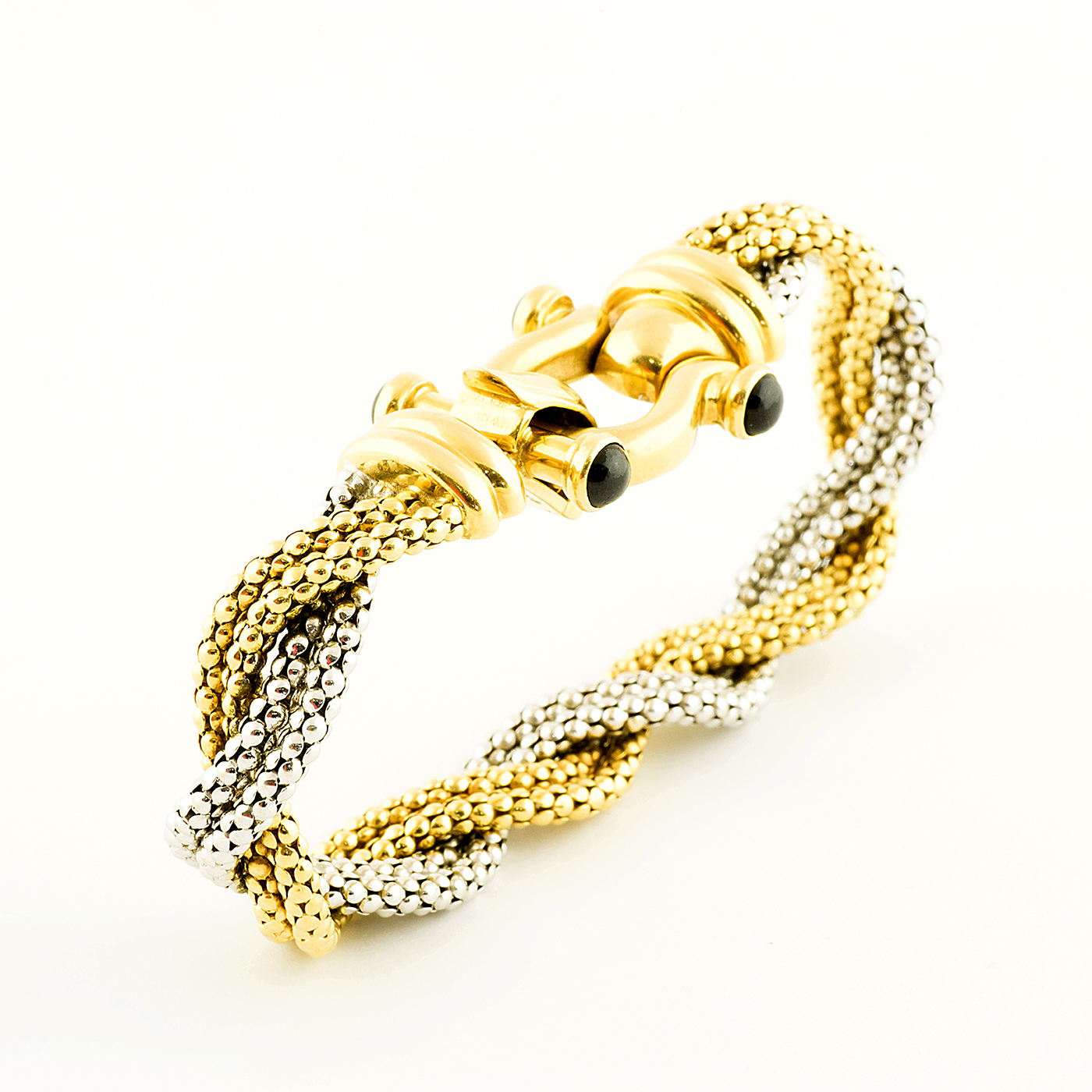 Pulsera en Oro Bicolor trenzada, con cabujón de zafiros. Pulsera en Oro Bicolor trenzada, con cabujón de zafiros.