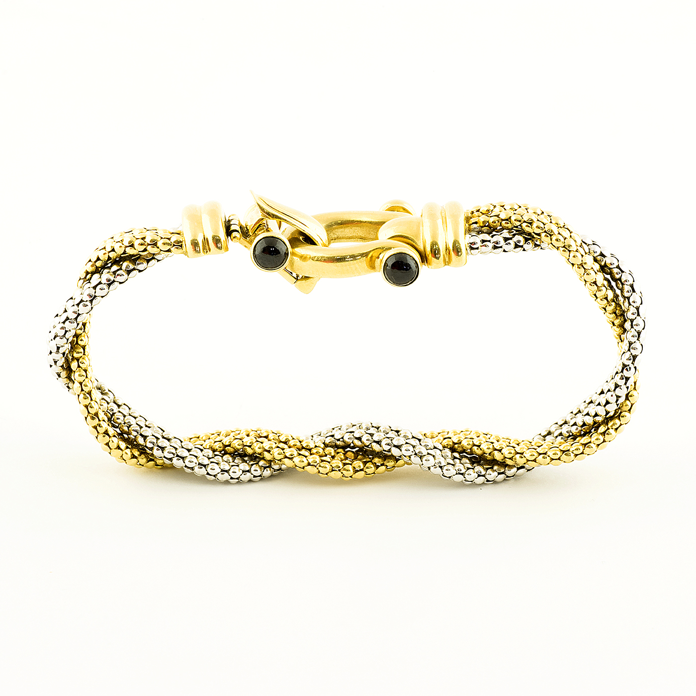 Pulsera en Oro Bicolor trenzada, con cabujón de zafiros. Pulsera en Oro Bicolor trenzada, con cabujón de zafiros.