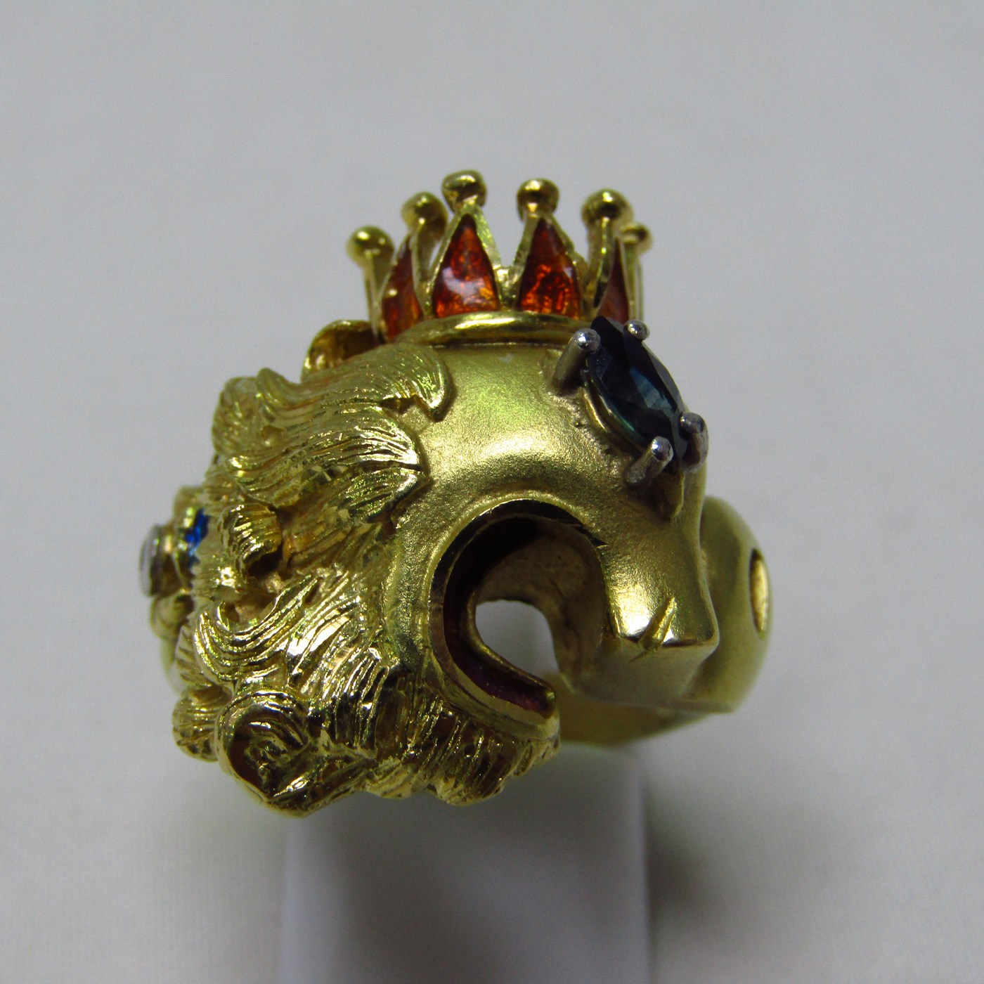 Sortija artesanal realizada en Oro de 18k con forma de felino coronado, con esmalte, zafiro y brillante. 12,54 gr. Sortija artesanal realizada en Oro de 18k con forma de felino coronado, con esmalte, zafiro y brillante. 12,54 gr.