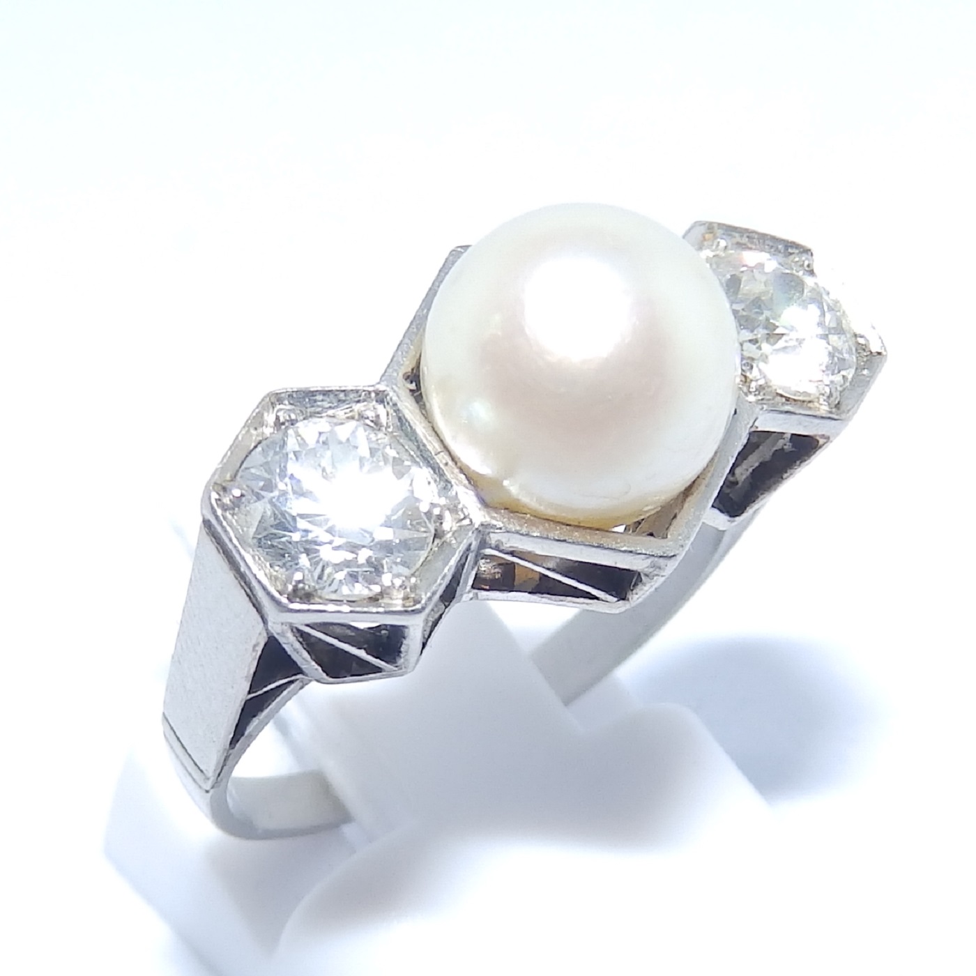 Sortija en Oro Blanco, con Perla Sedosa Central y Dos Diamantes Talla Antigua Europea de 0,55 ct. (H-I/SI1) y 0,46 ct. (J-K/SI1). Certificado IGE. Sortija en Oro Blanco, con Perla Sedosa Central y Dos Diamantes Talla Antigua Europea de 0,55 ct. (H-I/SI1) y 0,46 ct. (J-K/SI1). Certificado IGE.