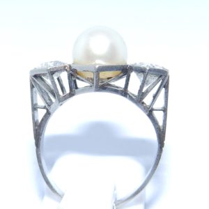 Sortija en Oro Blanco, con Perla Sedosa Central y Dos Diamantes Talla Antigua Europea de 0,55 ct. (H-I/SI1) y 0,46 ct. (J-K/SI1). Certificado IGE.