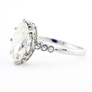 Sortija en Oro de 18k, con Diamante Natural, talla Marquise, de 1,52 ct. L/P2 (Certificado IGE) y 22 diamantes pequeños.