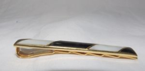 Pisacorbata en Oro de 18k con incrustaciones de nácar y esmalte negro. Peso: 11,10 gr.