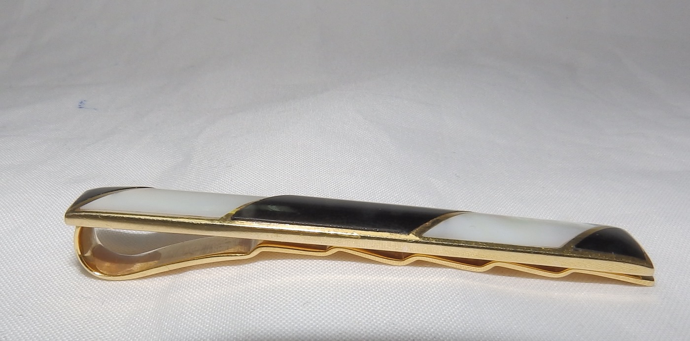Pisacorbata en Oro de 18k con incrustaciones de nácar y esmalte negro. Peso: 11,10 gr. Pisacorbata en Oro de 18k con incrustaciones de nácar y esmalte negro. Peso: 11,10 gr.