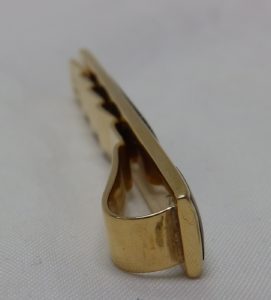 Pisacorbata en Oro de 18k con incrustaciones de nácar y esmalte negro. Peso: 11,10 gr.