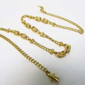 Collar en Oro Amarillo de 18k con eslabones barbados y cuatro lazadas. Peso 29,20 gr.