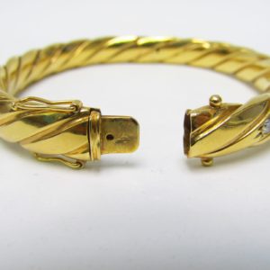 Pulsera Rígida y Oval, sogueada, en Oro de 18k con 5 Diamantes y 4 Rubíes, talla Brillante, de 0,50 ct. y 0,40 ct. respectivamente. Peso: 28 gr.