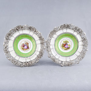 Pareja de Platos en Porcelana Limoges y Plata de Ley. España. Siglo XX.