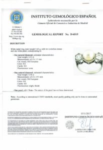 Sortija en Oro Blanco, con Perla Sedosa Central y Dos Diamantes Talla Antigua Europea de 0,55 ct. (H-I/SI1) y 0,46 ct. (J-K/SI1). Certificado IGE.
