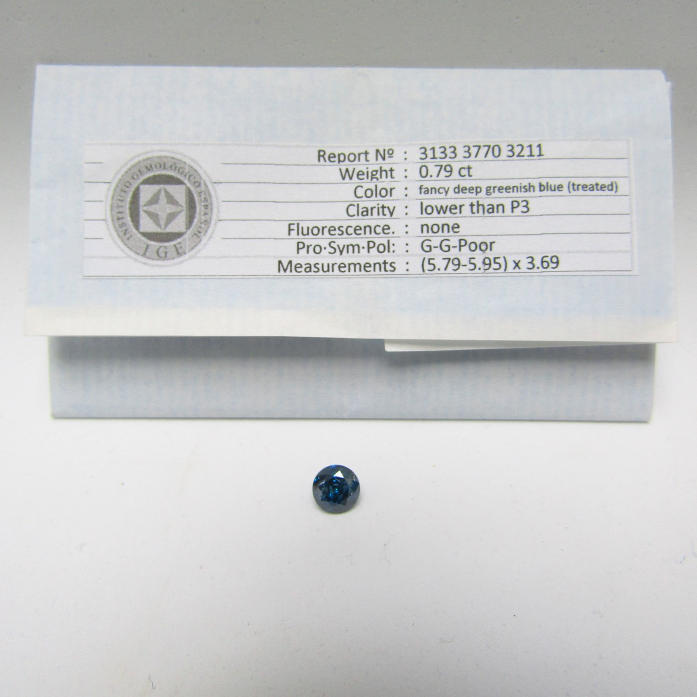 Diamante Natural de 0,79 ct. Talla: Brillante. Color: Fancy deep greenish blue. Pureza: P3. Tratado. Certificado IGE. Diamante Natural de 0,79 ct. Talla: Brillante. Color: Fancy deep greenish blue. Pureza: P3. Tratado. Certificado IGE.