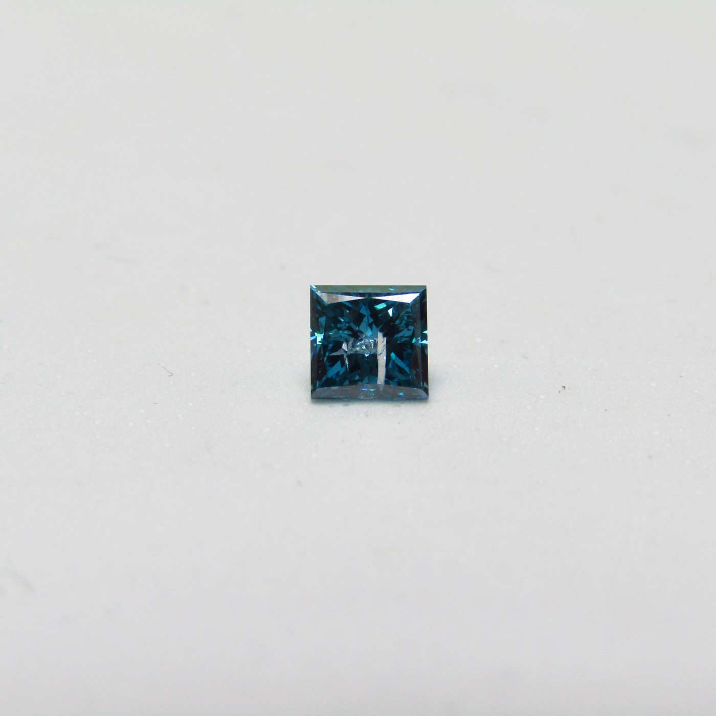 Diamante Natural de 0,87 ct. Talla: Princesa. Color: Fancy dark greenish blue. Pureza: P2. Tratado. Certificado IGE. Diamante Natural de 0,87 ct. Talla: Princesa. Color: Fancy dark greenish blue. Pureza: P2. Tratado. Certificado IGE.